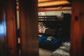 Rustic bunk beds with colorful bedding under exposed wood beams in a Fairbanks Alaska treehouse rental