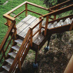 Wooden staircase and landing leading up to a treehouse rental in Fairbanks Alaska