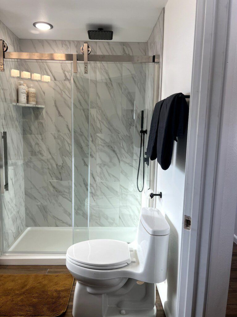 Treehouse bathroom with marble walk-in shower and black fixtures in Fairbanks, Alaska