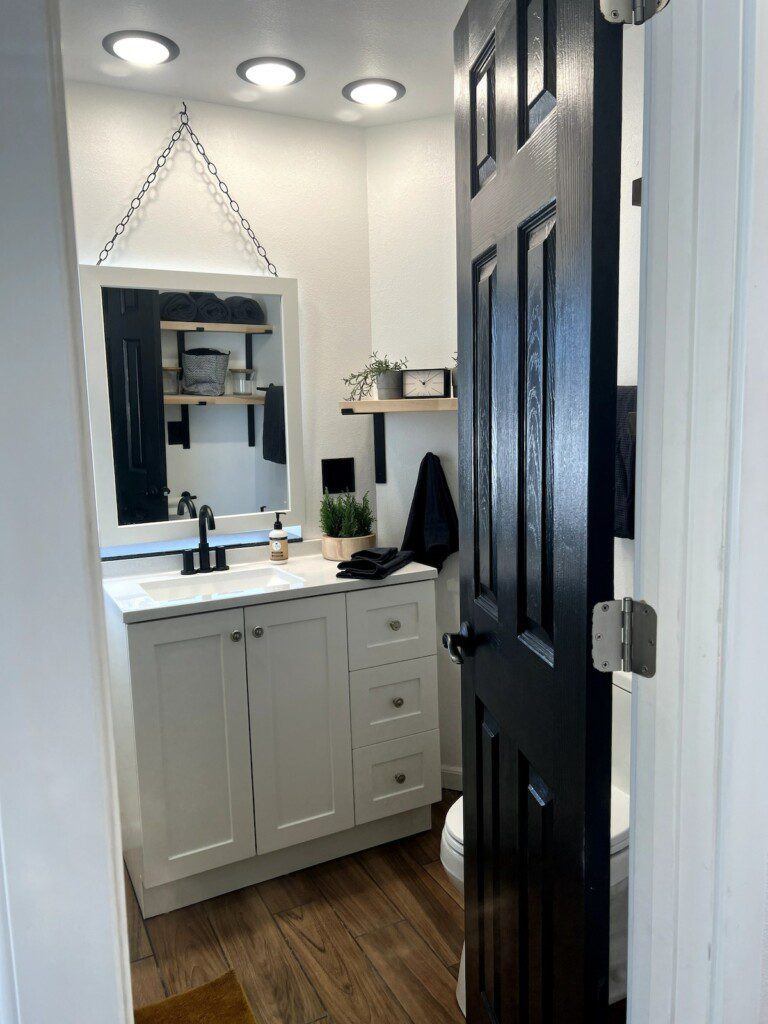 Compact and modern bathroom with black and white accents in a Fairbanks treehouse rental