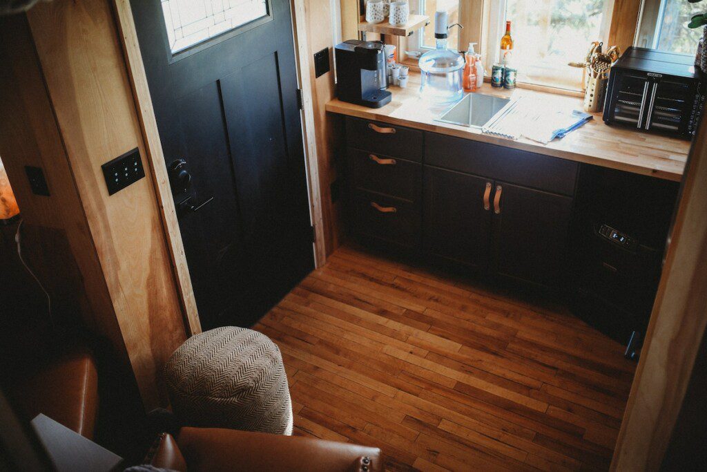 Warm wood kitchen with black cabinets and natural light in a Fairbanks Alaska treehouse rental