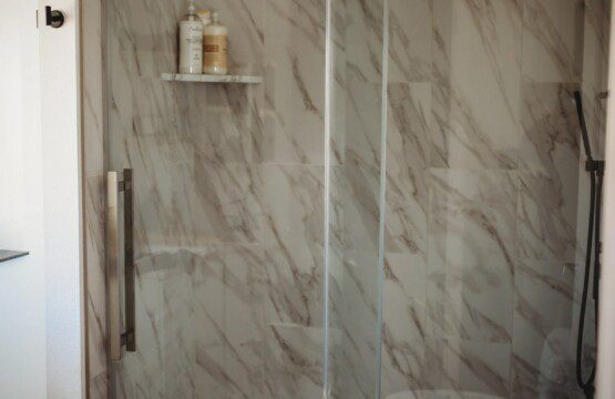 Treehouse bathroom with marble walk-in shower and black fixtures in Fairbanks, Alaska
