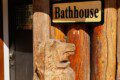 Wooden bathhouse sign mounted on a log wall at a rustic lodge in Fairbanks, Alaska