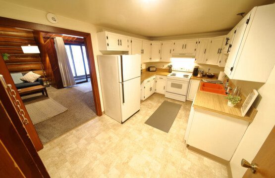 Rustic kitchen with white cabinets and wood accents in a Fairbanks Alaska cabin