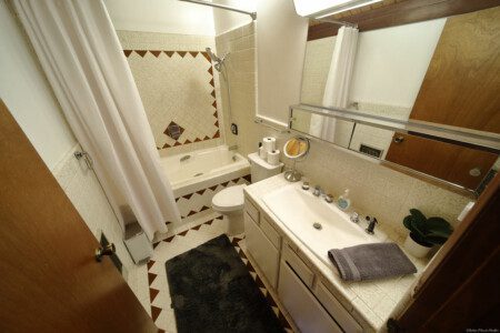 Warm cabin-style bathroom in Fairbanks Alaska with wooden ceiling, soaking tub, and tile floors