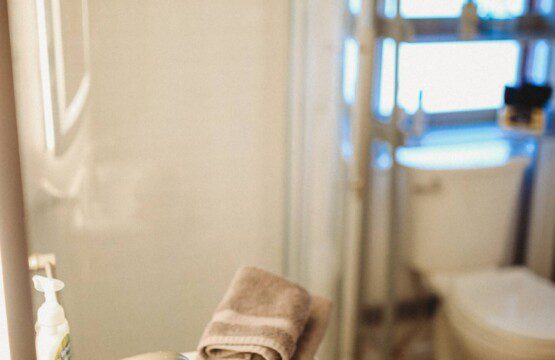 Modern bathroom with mirror and sink inside restored railcar lodge in Fairbanks.