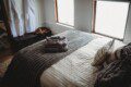 Comfortable bed with folded towels inside Alaska railroad car lodge in Fairbanks.