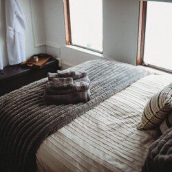 Comfortable bed with folded towels inside Alaska railroad car lodge in Fairbanks.