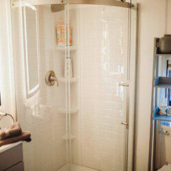 Bright bathroom with glass shower, shelves, and toilet in a stylish Fairbanks Alaska adventure rental