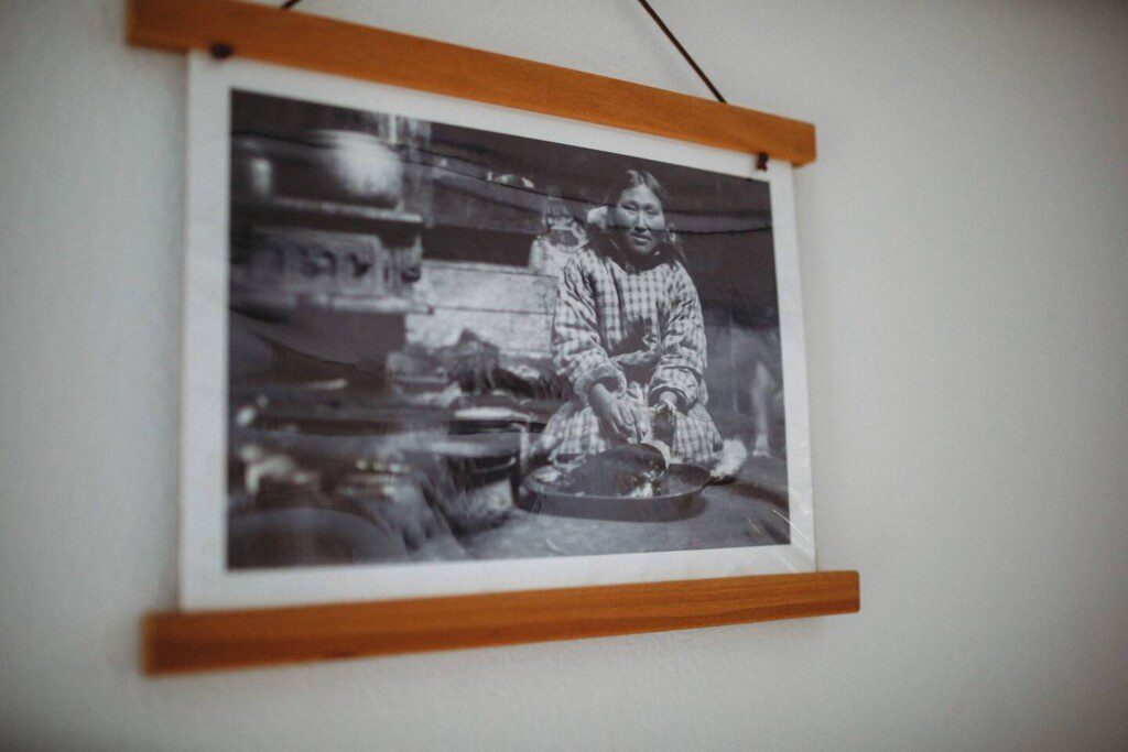 Framed historic Fairbanks prints on white wall in vintage railcar lodge.
