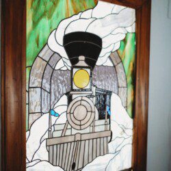 Framed historic Fairbanks prints on white wall in vintage railcar lodge.