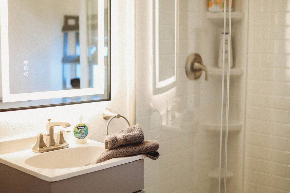 Modern bathroom with mirror and sink inside restored railcar lodge in Fairbanks.
