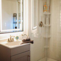 Modern bathroom with mirror and sink inside restored railcar lodge in Fairbanks.