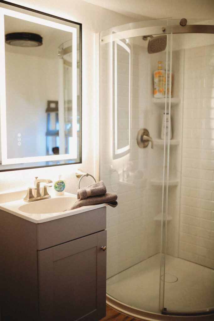 Modern bathroom with mirror and sink inside restored railcar lodge in Fairbanks.