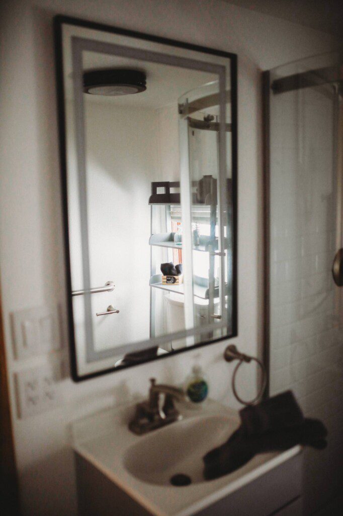 Modern bathroom with mirror and sink inside restored railcar lodge in Fairbanks.