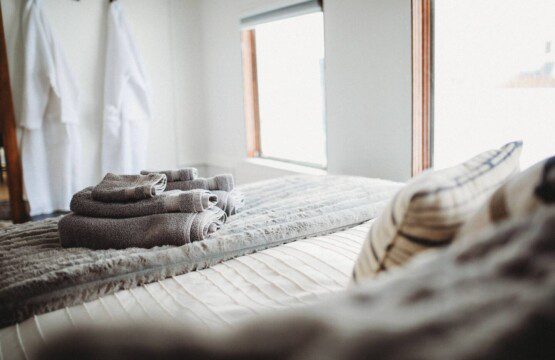 Comfortable bed with folded towels inside Alaska railroad car lodge in Fairbanks.