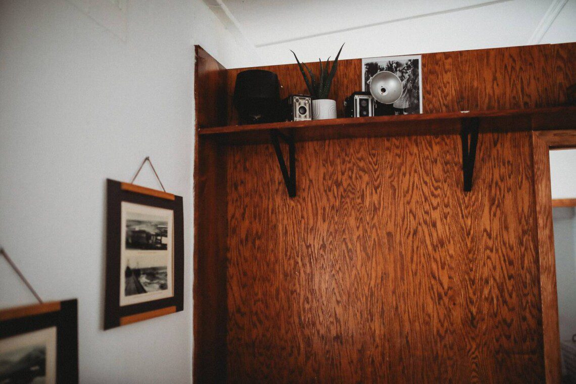 Shelf with vintage cameras and framed prints in Alaska railcar lodge in Fairbanks.