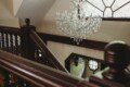 Crystal chandelier above wooden staircase in a unique Fairbanks Alaska adventure lodge rental