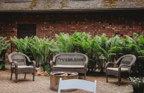 Wicker chairs and fire pit on brick patio at treehouse-style Alaska adventure lodge in Fairbanks