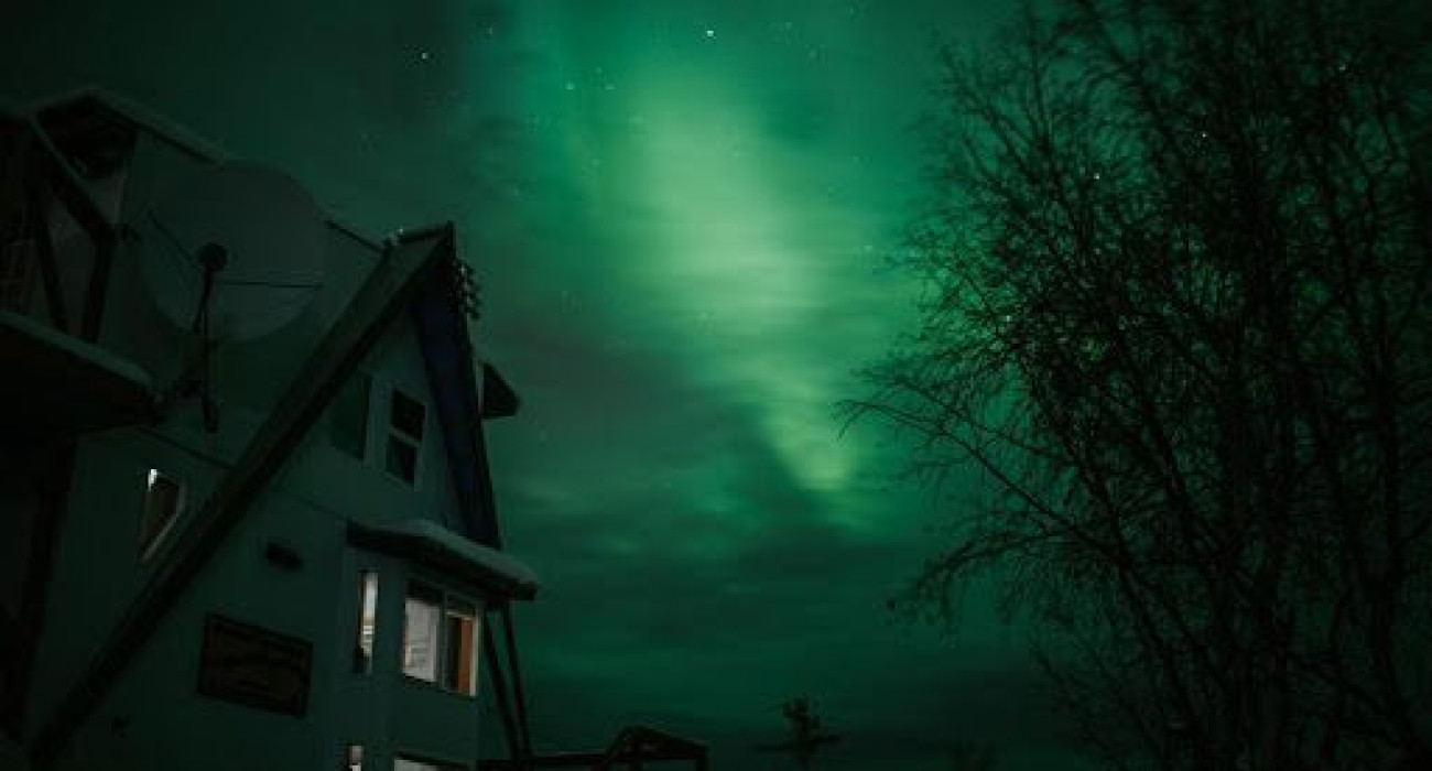 Treehouse-style rental in Fairbanks, Alaska illuminated by northern lights